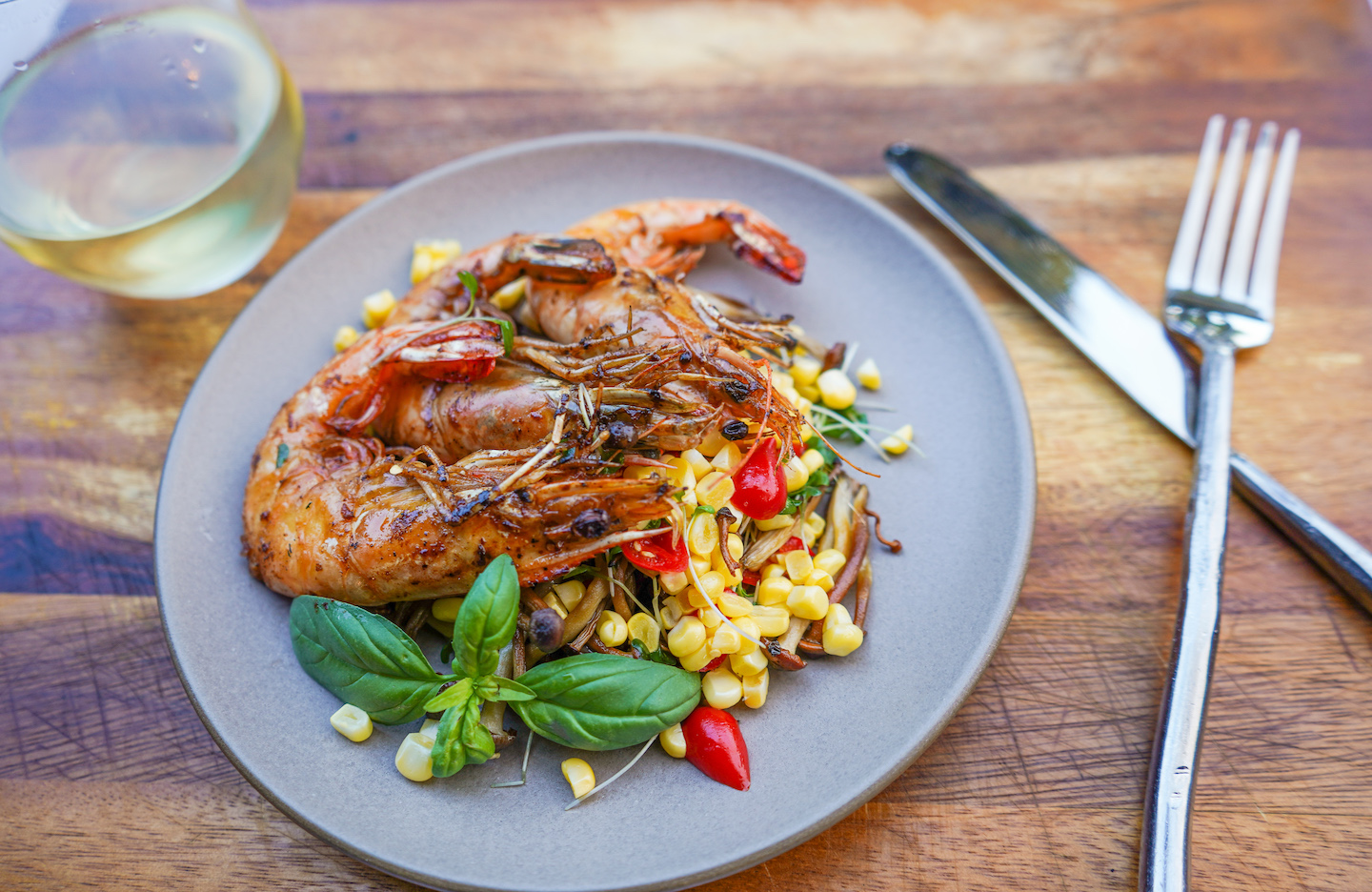Grilled prawns with seasonal corn, peppers, and fresh basil